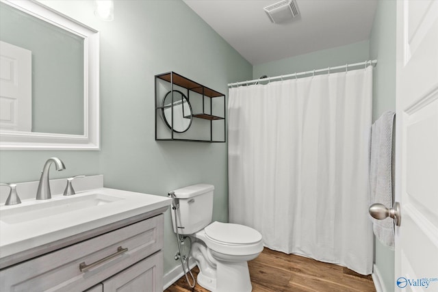 full bath with visible vents, vanity, wood finished floors, toilet, and a shower with shower curtain