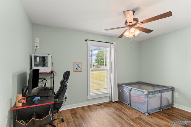 office area with baseboards, a ceiling fan, and wood finished floors