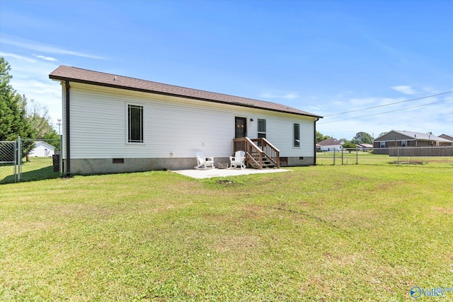 rear view of house featuring fence, a lawn, a patio area, and crawl space