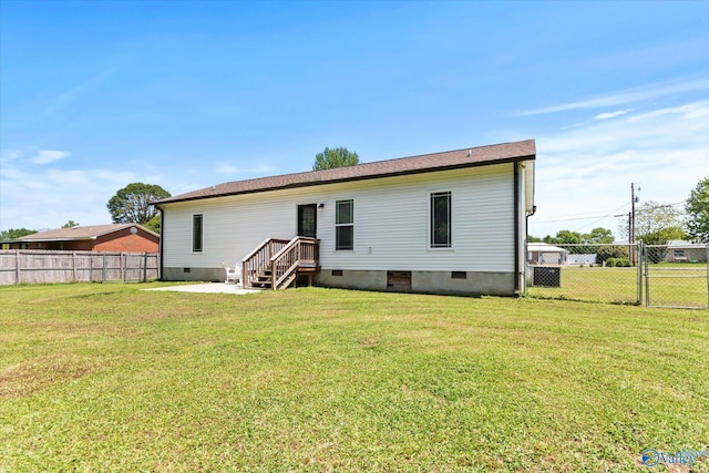 back of property featuring a lawn, fence, and crawl space