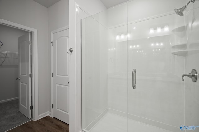 418 Tracer St, Huntsville, AL 35811 - bathroom with a shower stall, wood finished floors, a spacious closet, and baseboards
