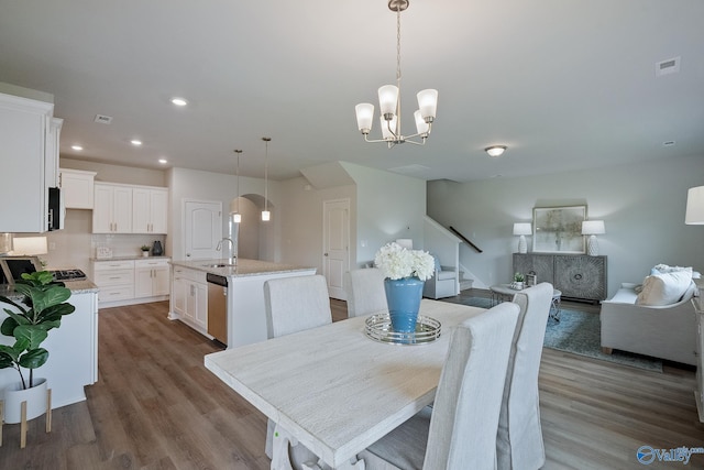 418 Tracer St, Huntsville, AL 35811 - dining room with stairs, dark wood-type flooring, arched walkways, recessed lighting, and a chandelier