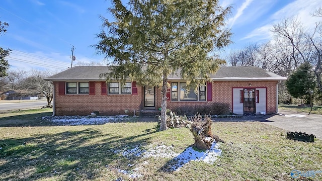 ranch-style home featuring brick siding, a front yard, and a shingled roof