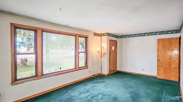 carpeted empty room featuring baseboards