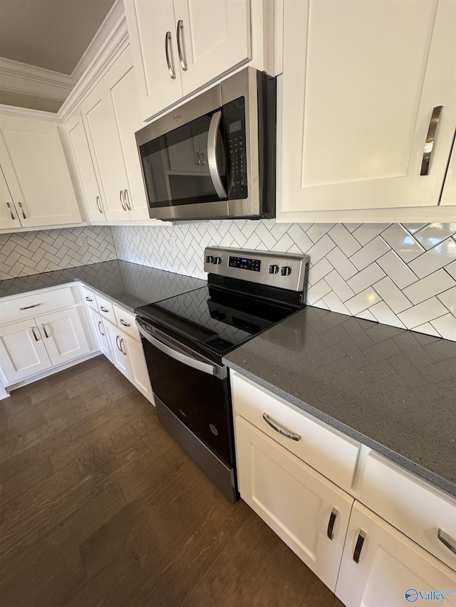 kitchen with white cabinets, backsplash, stainless steel appliances, crown molding, and dark wood-type flooring