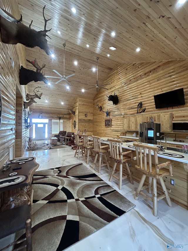 interior space with sink, wooden walls, high vaulted ceiling, and wooden ceiling