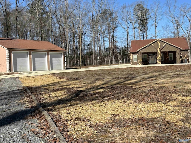 view of yard featuring a garage and an outbuilding