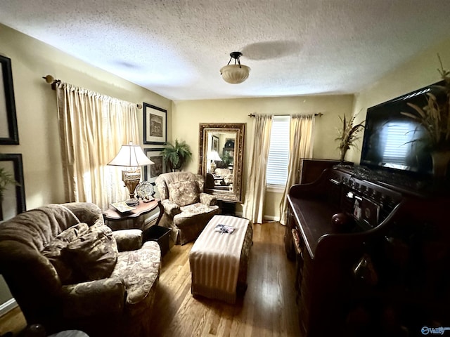 interior space with a textured ceiling, baseboards, and wood finished floors