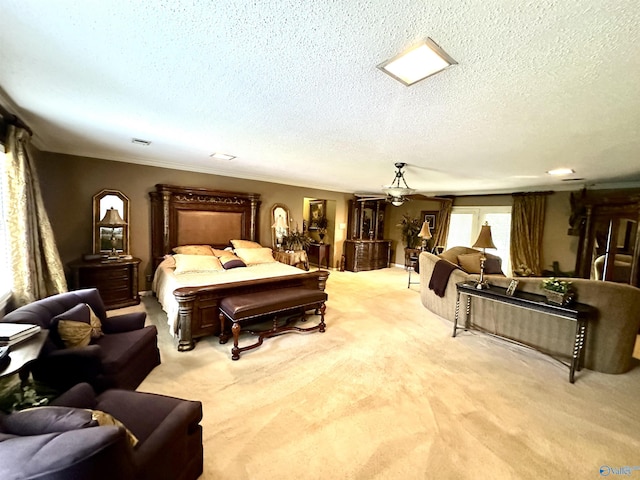 bedroom with light colored carpet, visible vents, and a textured ceiling