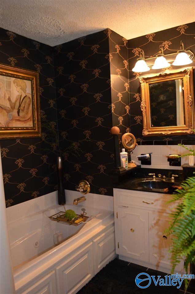 full bath with a textured ceiling, a jetted tub, vanity, and wallpapered walls