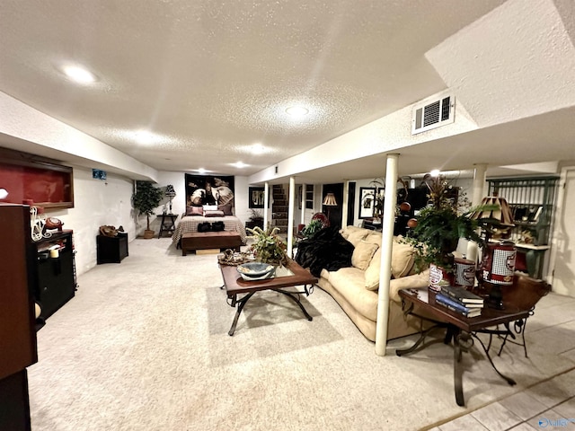 living area with carpet, visible vents, and a textured ceiling