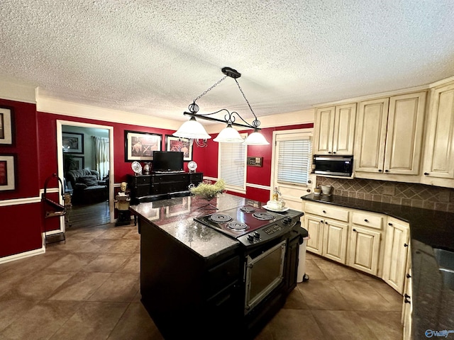 kitchen with pendant lighting, stainless steel microwave, black range with electric stovetop, backsplash, and a textured ceiling