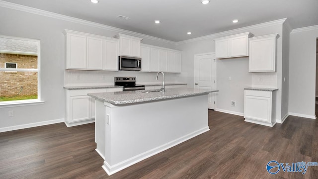 kitchen with an island with sink, appliances with stainless steel finishes, sink, and white cabinets