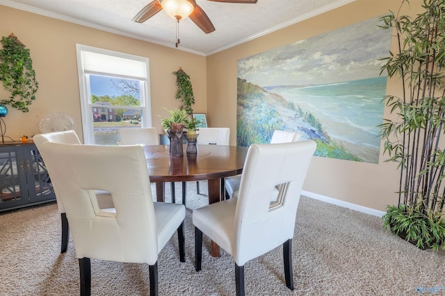 carpeted dining room featuring a ceiling fan, baseboards, and ornamental molding