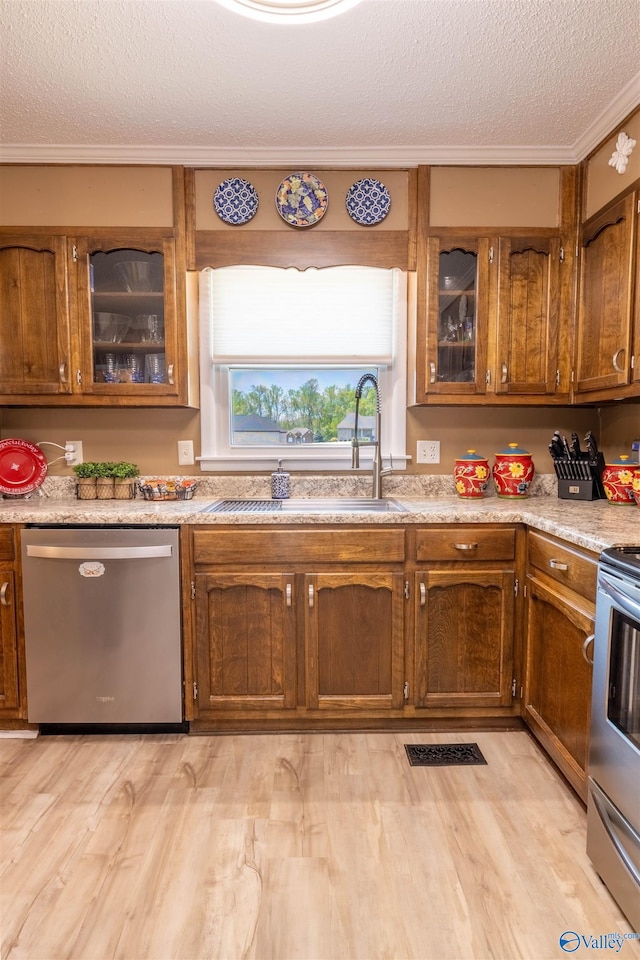 kitchen with brown cabinetry, stainless steel appliances, and a textured ceiling