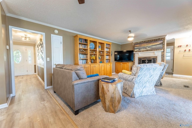 living area with crown molding, a textured ceiling, and visible vents