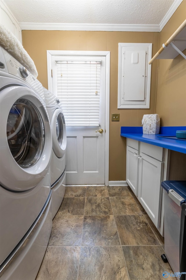 laundry area featuring ornamental molding, washing machine and dryer, stone finish flooring, and a textured ceiling