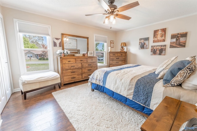 bedroom with a ceiling fan, ornamental molding, wood finished floors, and multiple windows