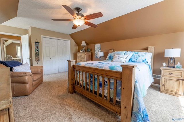 bedroom featuring a closet, a ceiling fan, vaulted ceiling, and light colored carpet