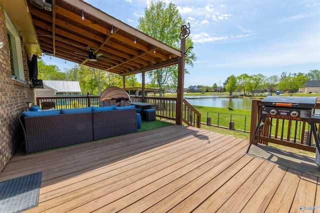 wooden terrace with a water view and outdoor lounge area