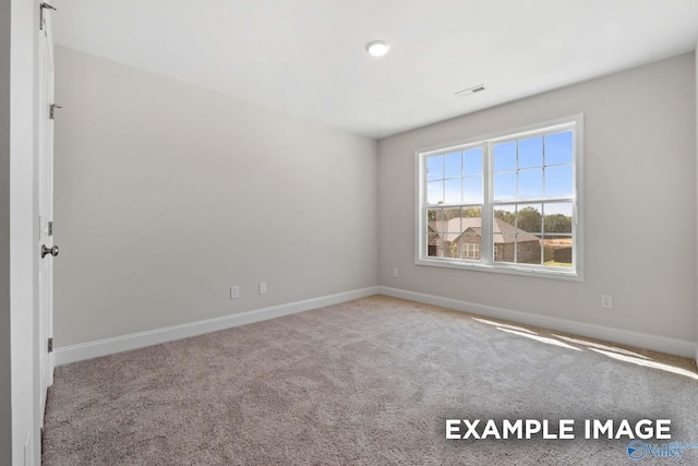 empty room featuring visible vents, light carpet, and baseboards