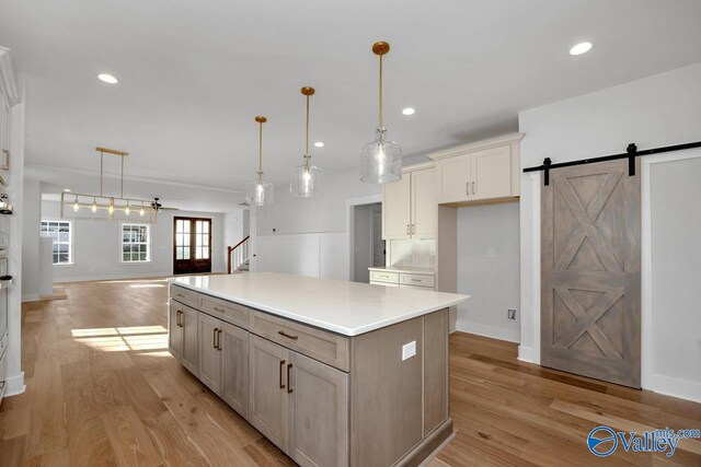 kitchen with pendant lighting, decorative backsplash, a barn door, and a kitchen island