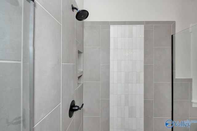 interior details featuring tiled shower