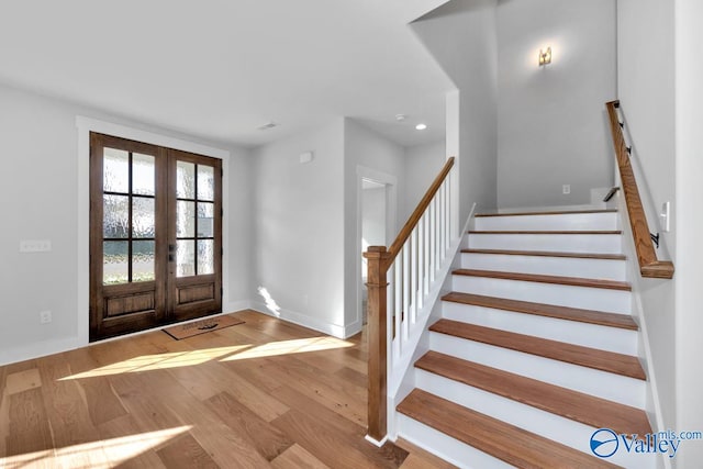 foyer with light hardwood / wood-style flooring and french doors