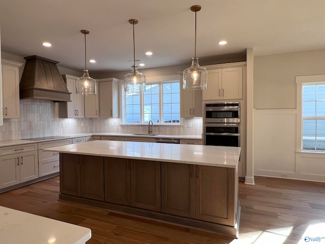 kitchen featuring decorative light fixtures, dark hardwood / wood-style floors, custom range hood, and a kitchen island