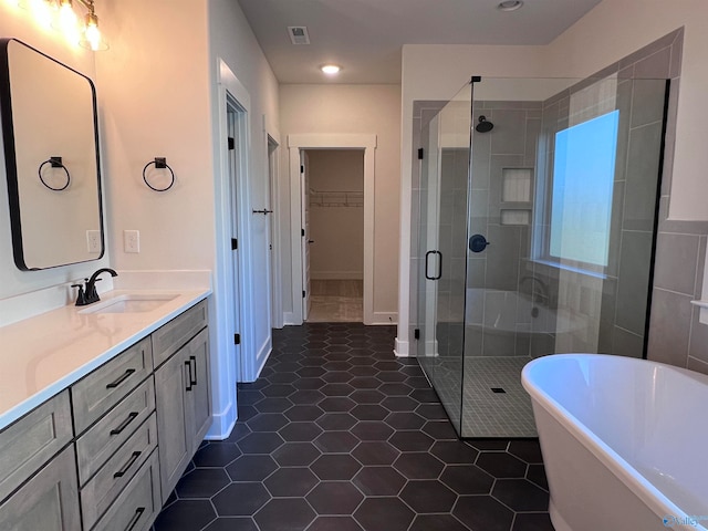 bathroom with tile patterned flooring, vanity, and plus walk in shower