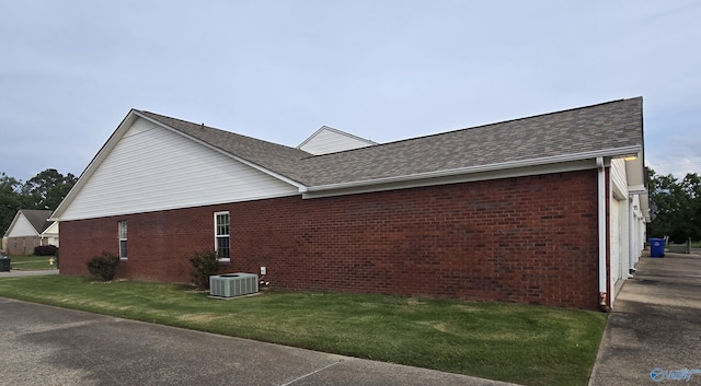 113 Sycamore Pl, Athens, AL 35611 - view of side of home featuring brick siding, central AC unit, a lawn, and roof with shingles