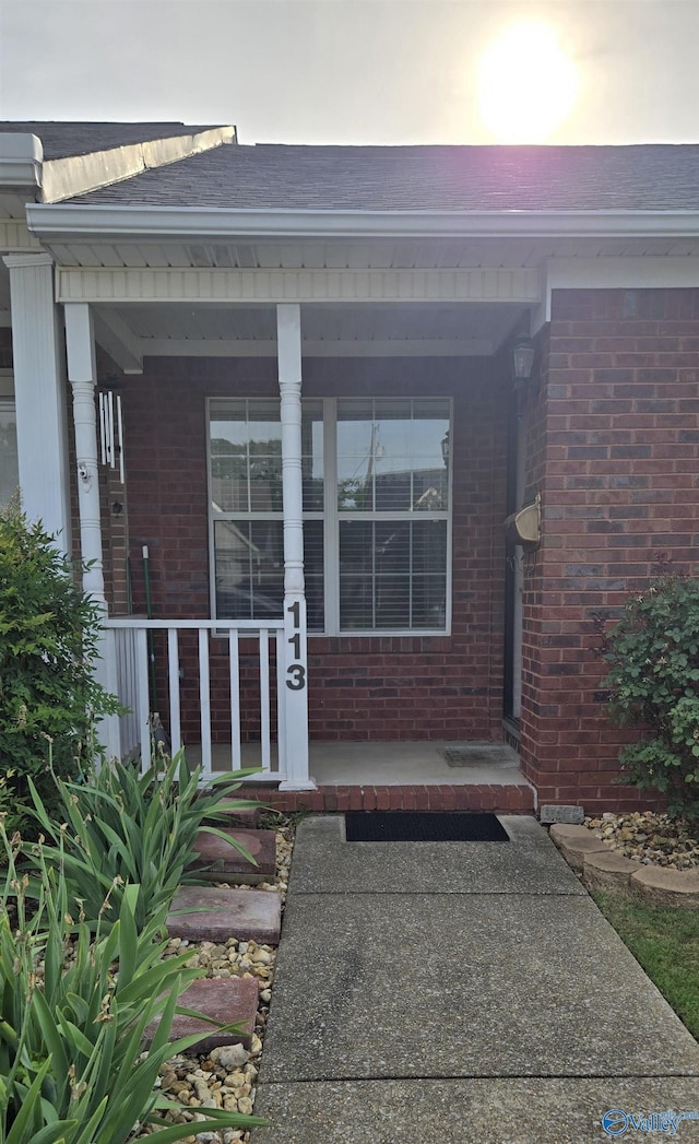 113 Sycamore Pl, Athens, AL 35611 - doorway to property featuring brick siding, a porch, and roof with shingles