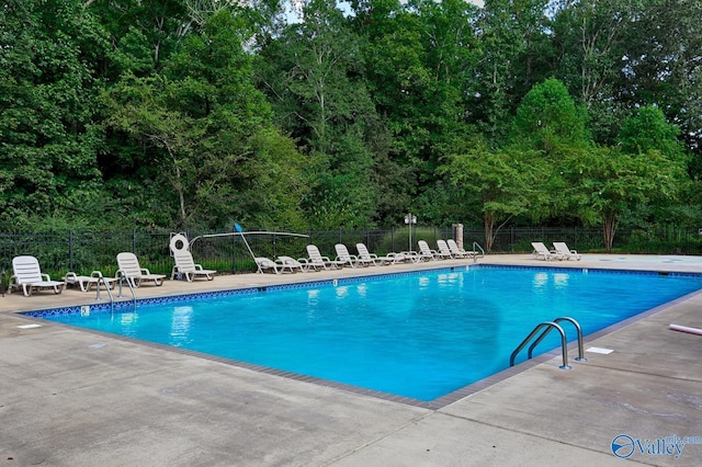 community pool featuring fence and a patio