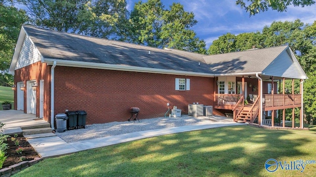 990 Chambers Rd, Double Springs, AL 35553 - back of property featuring brick siding, a yard, a garage, central air condition unit, and roof with shingles