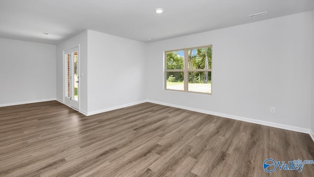 unfurnished room with wood-type flooring