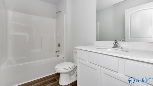 full bathroom with vanity, toilet,  shower combination, and hardwood / wood-style floors