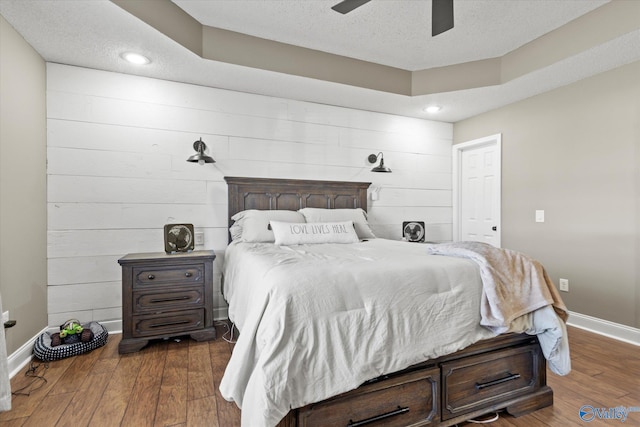 bedroom featuring a textured ceiling, dark hardwood / wood-style floors, and ceiling fan