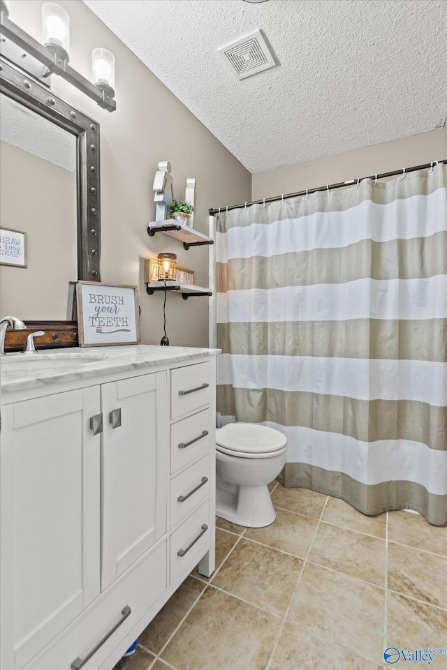 bathroom featuring tile patterned floors, walk in shower, vanity, a textured ceiling, and toilet