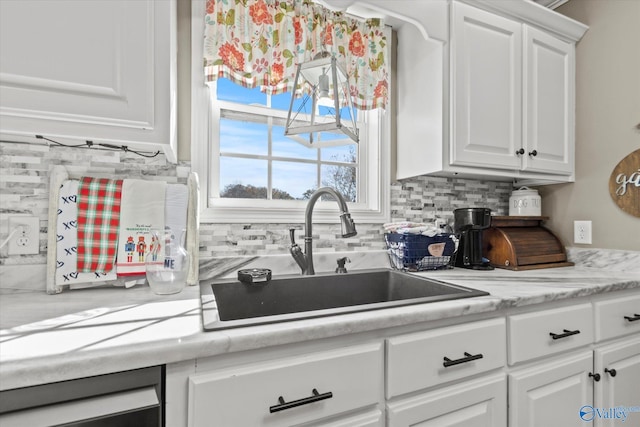 kitchen featuring white cabinetry, sink, and tasteful backsplash