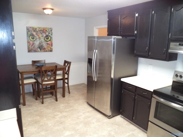 kitchen featuring appliances with stainless steel finishes, range hood, light countertops, and light floors