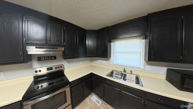 kitchen with stainless steel electric range oven, light countertops, a sink, dark cabinetry, and under cabinet range hood