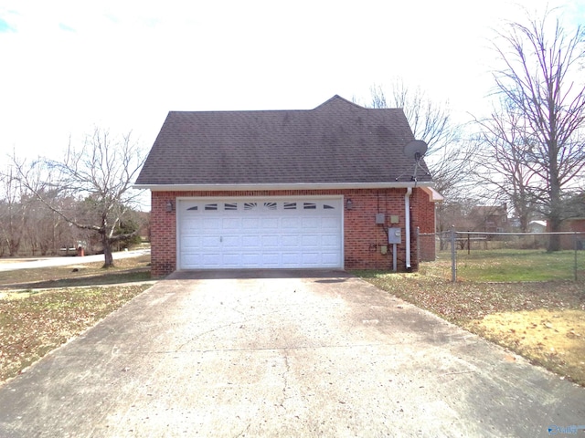 view of home's exterior featuring driveway, brick siding, a shingled roof, and fence