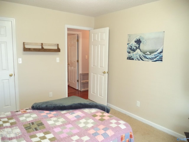 carpeted bedroom with a textured ceiling and baseboards