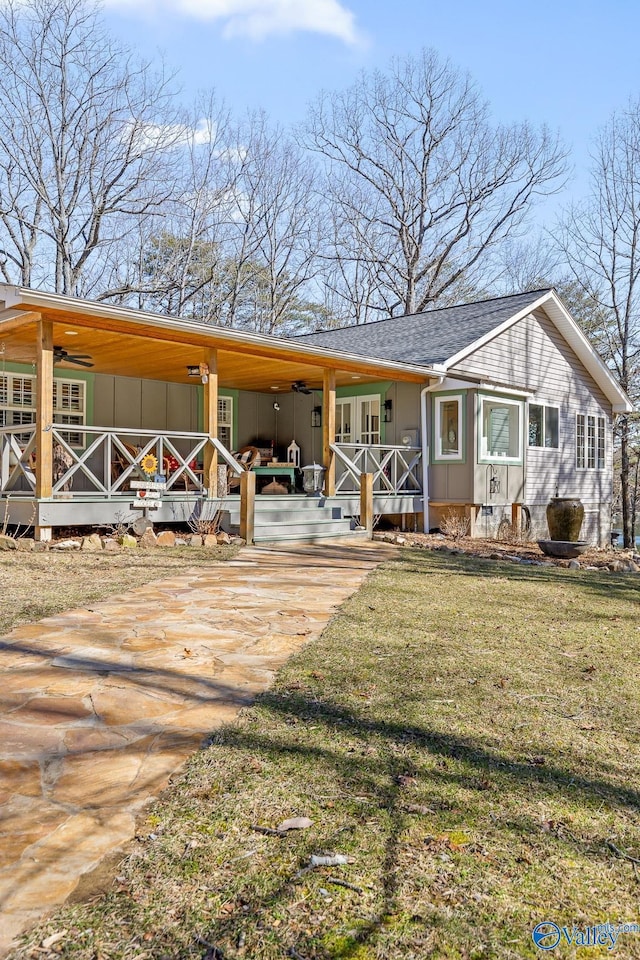 view of front facade featuring a porch, a shingled roof, concrete driveway, board and batten siding, and a front yard