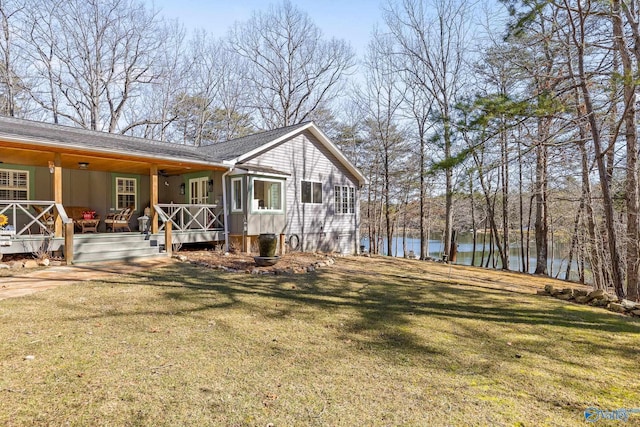 exterior space with a deck with water view and a yard