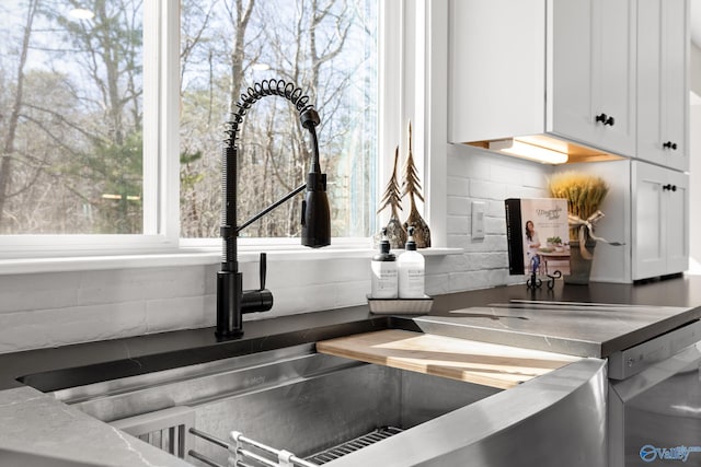 interior details featuring tasteful backsplash and white cabinets