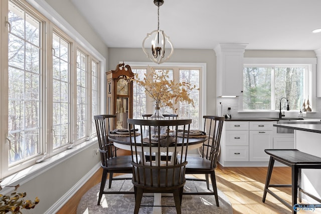 dining room with light wood-style flooring, baseboards, and a wealth of natural light