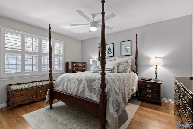 bedroom with ceiling fan, light wood finished floors, and baseboards