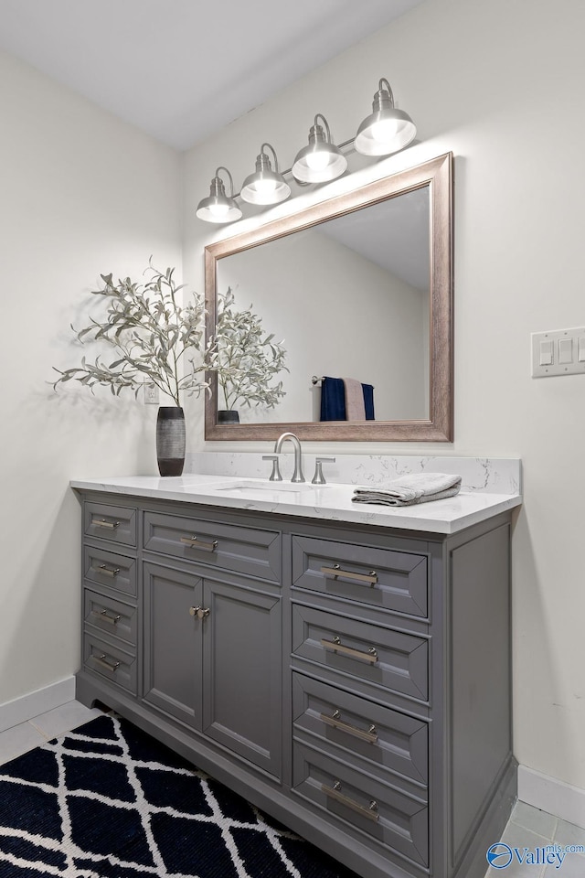 bathroom with baseboards, vanity, and tile patterned floors