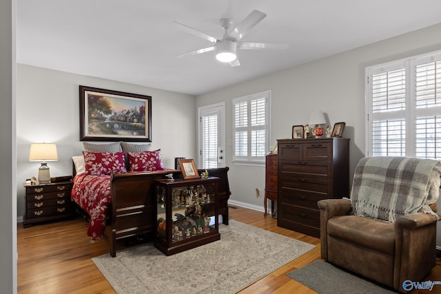 bedroom with a ceiling fan, baseboards, and light wood finished floors